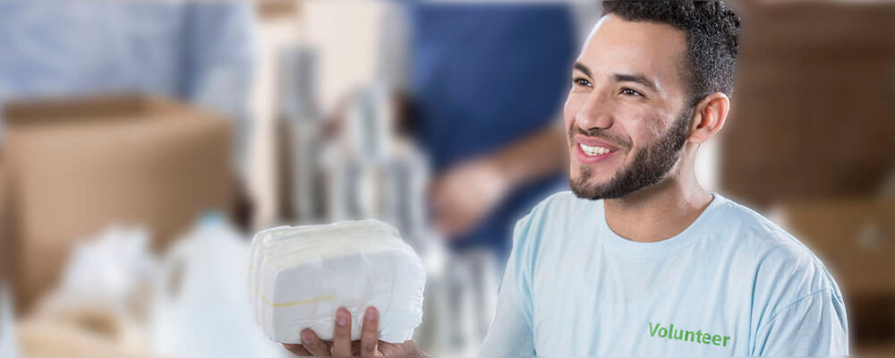 young man volunteer with adult diaper donation 