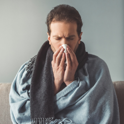 sick man holding a tissue to the nose