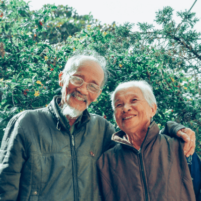 senior couple smiling outside 