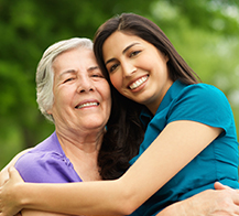 young woman and grandmother hugging